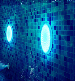 Illuminated underwater lights in a tiled pool, enhancing RES Group's underwater lighting accessories for pools