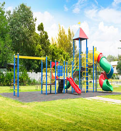 A colorful playground with slides and swings, designed by RES Group for safe outdoor play equipment