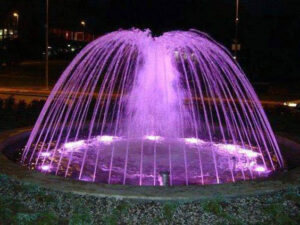 A radiant purple dome fountain, constructed and designed by RES Group, illuminating outdoor spaces with elegance.