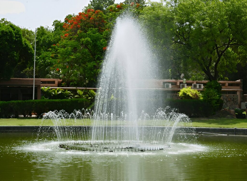 Gray water streams flowing against curved glass tower exterior